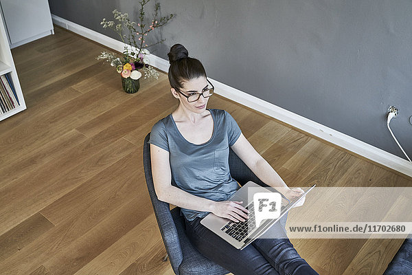 Junge Frau mit Laptop zu Hause