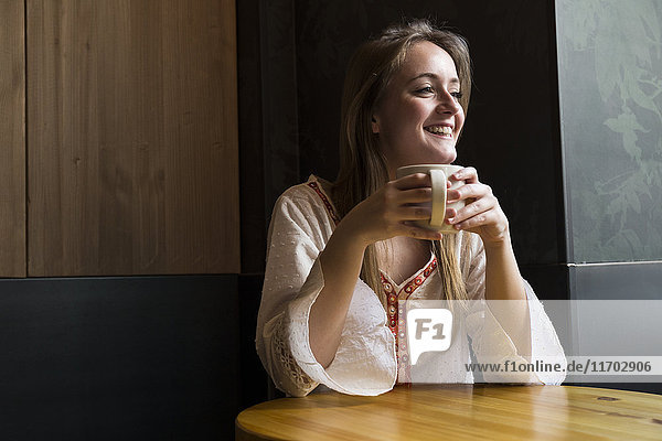 Portrait of smiling woman with cup of coffee in a coffee shop