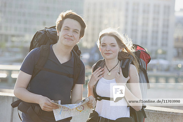 Deutschland  Berlin  Junges Paar  das mit Rucksäcken durch Berlin reist  Karte ansehen