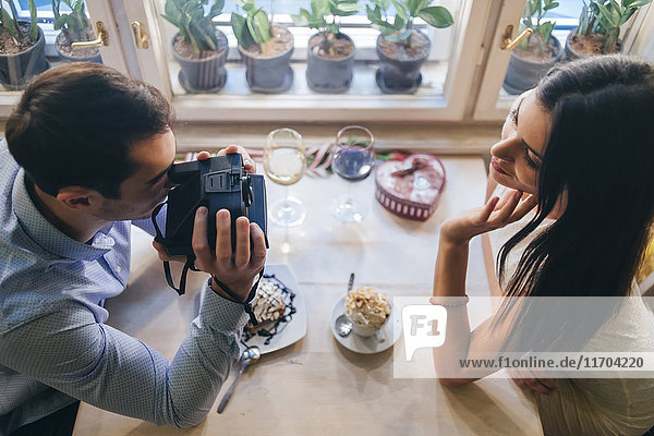 Young couple taking instant photos  top view