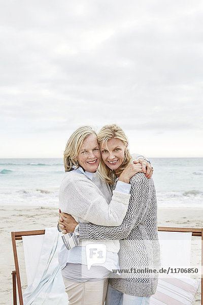 Mother and daughter embracing on the beach