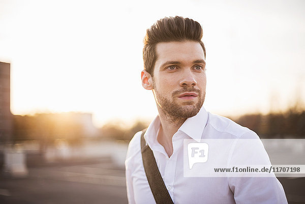Portrait of young businessman at sunset
