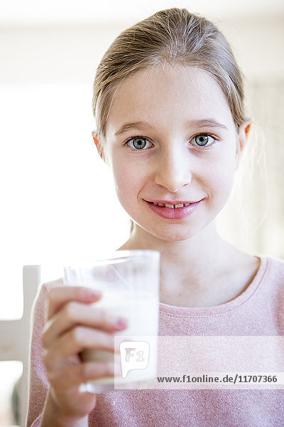 Porträt eines lächelnden Mädchens mit Milchglas