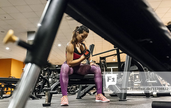 Woman lifting dumbbell in gym
