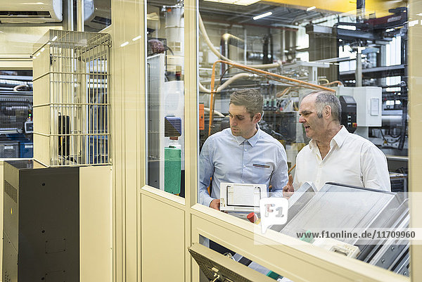 Two men talking in factory shop floor