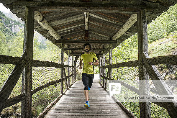 Italien  Alagna  Mann läuft auf Holzbrücke in den Bergen