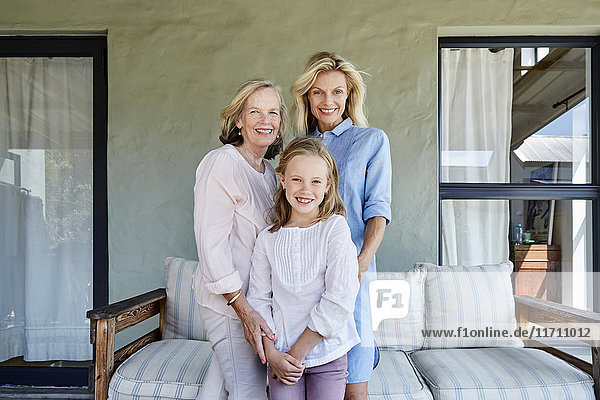Familienbild des kleinen Mädchens mit Mutter und Großmutter auf der Terrasse