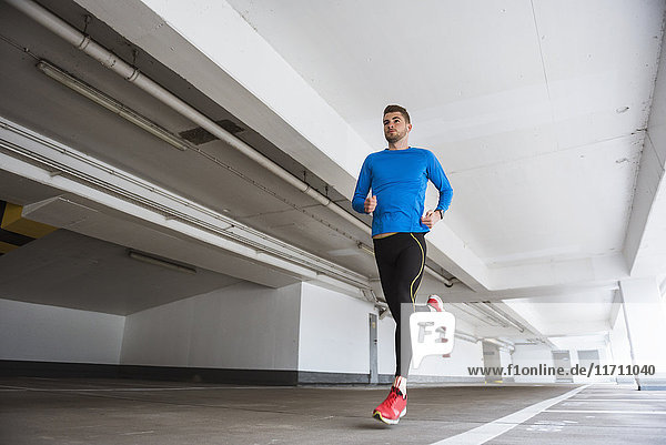 Young man running in a parking garage