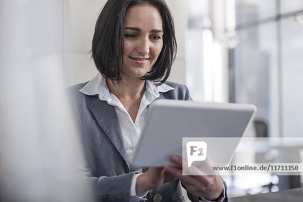 Businesswoman holding digital tablet in office