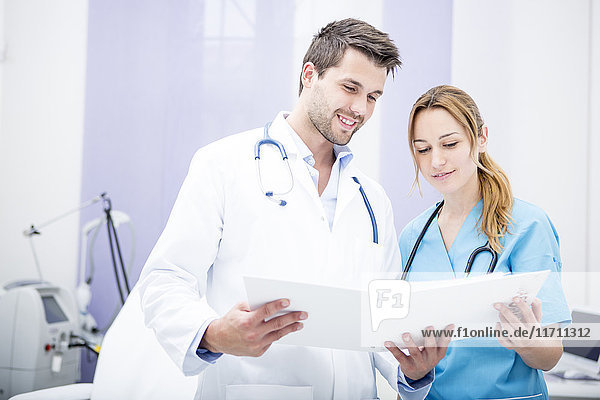 Two smiling doctors holding folder