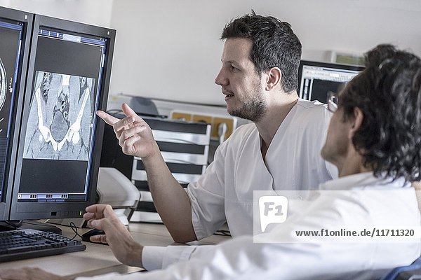 Two doctors discussing x-ray image on computer screen