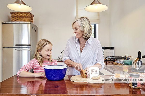 Grandmother and granddaughter preparing food in the kitchen