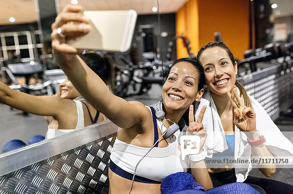 Zwei Frauen  die nach dem Training in der Turnhalle einen Selfie machen.