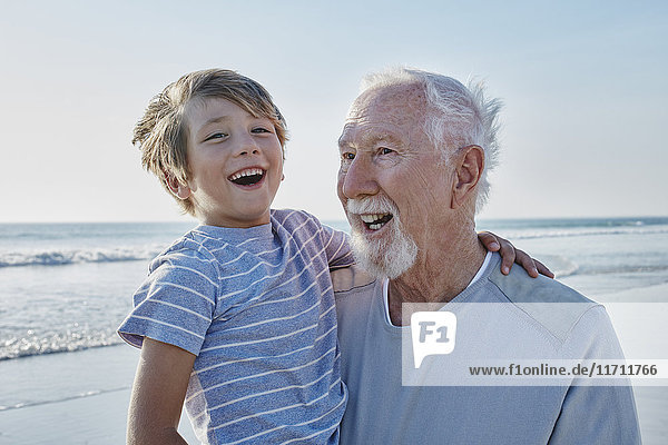 Glücklicher Großvater mit Enkel am Strand