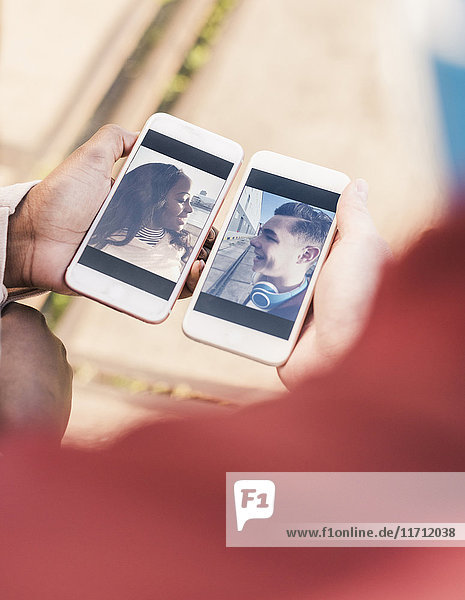 Hände halten Smartphones mit Bildern eines jungen Paares