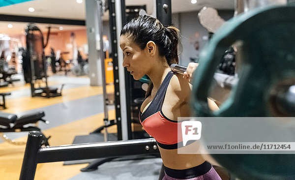 Woman lifting barbell in gym