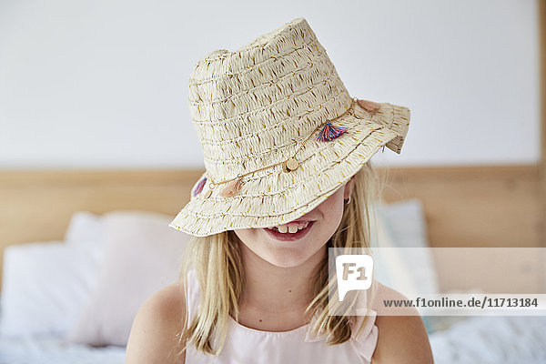 Smiling little girl wearing straw hat