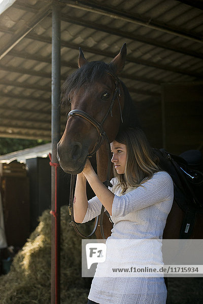 Junge Frau mit Pferd auf dem Bauernhof