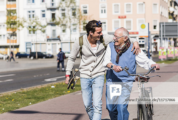 Happy senior man with adult grandson in the city on the move