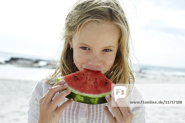Little girl eating water melon in the beach