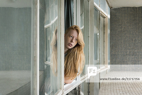 Ginger woman looking out of window