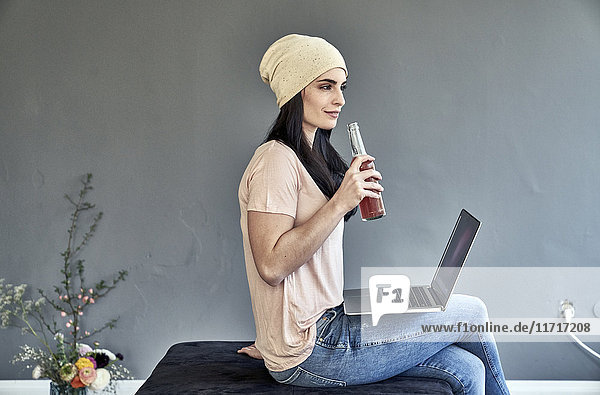 Junge Frau mit Laptop-Halteflasche