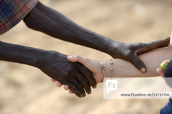 Burkina Faso  alter afrikanischer Mann beim Händeschütteln mit weißer Frau