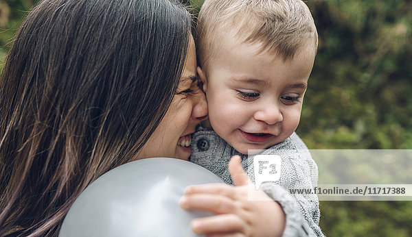 Glückliche Mutter und kleiner Junge mit Ballon