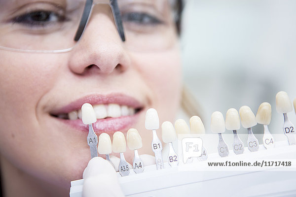 Woman at the dentist choosing color for teeth whitening