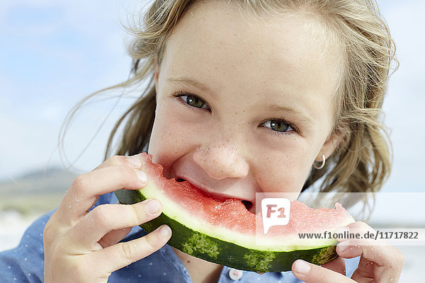 Little girl eating water melon in the beach