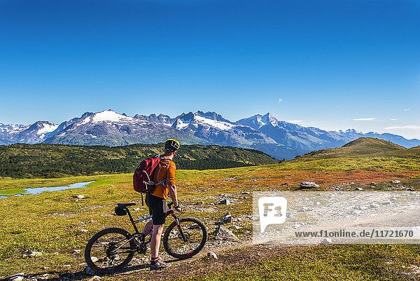 A man riding a mountain bike on the Lost Lake Trail near Seward  Southcentral Alaska  USA