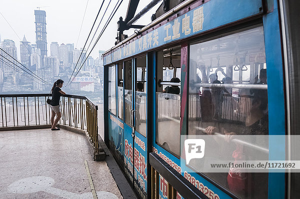 'Cable car crossing Yangtze river in Chongqing the city as background covered by the fog; Chongqing China'