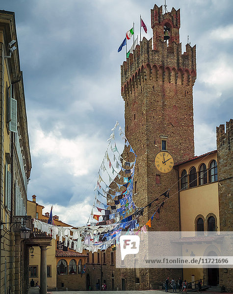 Ein Uhrenturm und Wäsche  die über eine Straße von einem Gebäude zum anderen hängt; Siena  Toskana  Italien'.