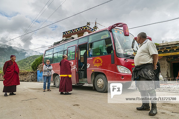 'Local bus from Daocheng to Sangrila monks tourists and local people traveling together west of Sichuan province; Daocheng Sichuan China'
