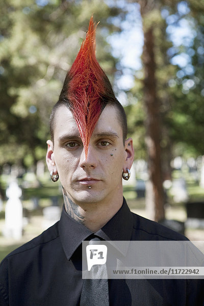 Ein junger Mann mit rotem Irokesenschnitt auf einem Friedhof; Edmonton  Alberta  Kanada'.