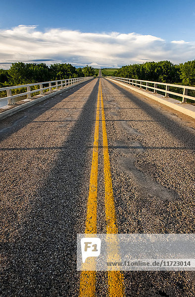 'Double solid yellow line down a paved road; Herschel  Saskatchewan  Canada'