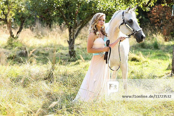 Eine junge Frau in einem wallenden Kleid mit einem weißen Pferd; Oregon  Vereinigte Staaten von Amerika'.