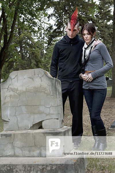 Ein junger Mann und eine junge Frau  die sich gegenseitig auf einem Friedhof unterstützen; Edmonton  Alberta  Kanada'.