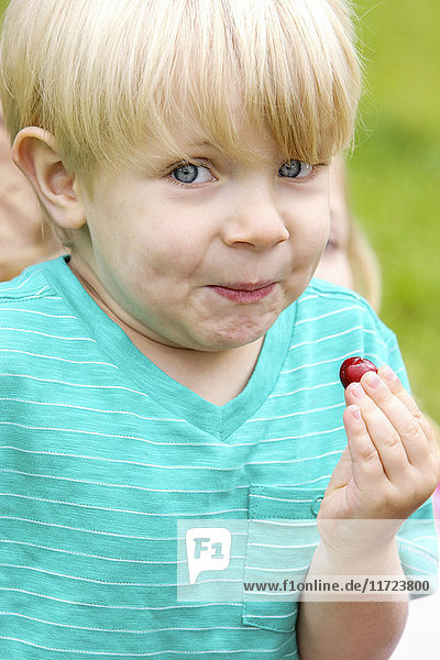 'A young boy with a funny facial expression after tasting a sour berry; Oregon  United States of America'