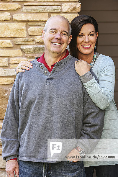 'Portrait of a couple with a stone wall behind them; Oregon  United States of America'