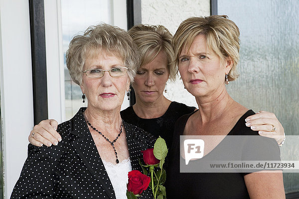 Eine Mutter und ihre beiden Töchter trauern um einen Todesfall; Edmonton  Alberta  Kanada'.