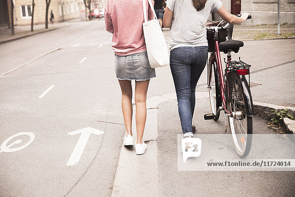 Young women walking with bike