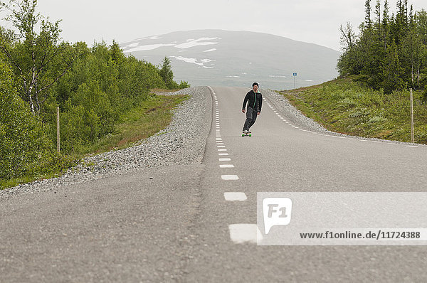 Mann fährt Skateboard auf der Straße