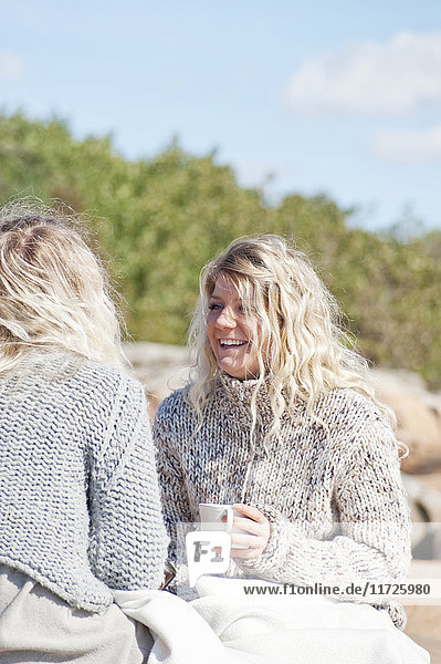 Glückliche Frauen beim Kaffee trinken im Freien