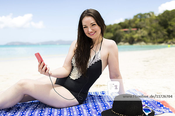 USA  Jungferninseln  Saint Thomas  Frau hört Musik am Strand in den Sommerferien