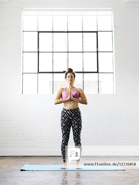 Frau übt Yoga auf Übungsmatte