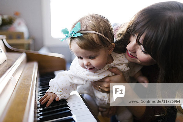 Mutter mit Tochter (12-17 Monate) beim Klavierspielen