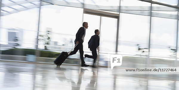 Businessmen running with suitcase  rushing in airport