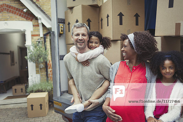 Portrait smiling pregnant multi-ethnic young family moving into new house