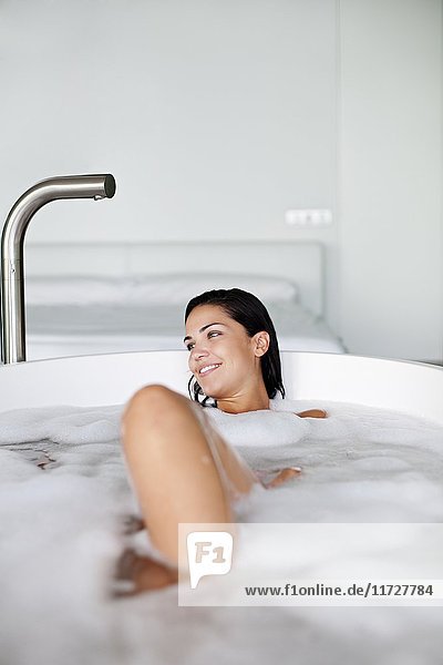 Young pretty brunette woman enjoying a bath